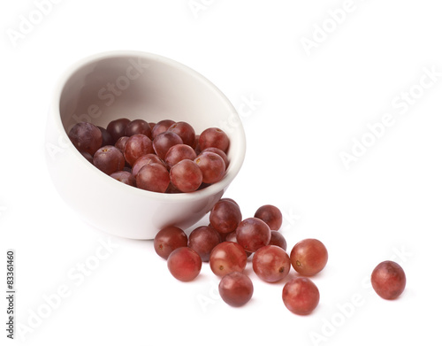 Dark red grapes spilled out of bowl