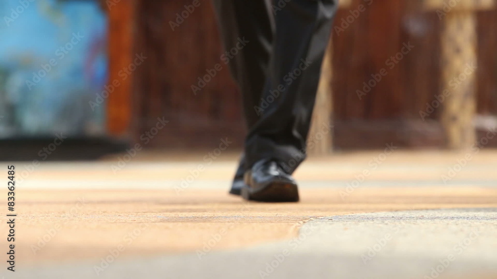 man in black trousers and shoes puts his foot on tip toe and goes man in black trousers and shoes puts his foot on tip toe and goes