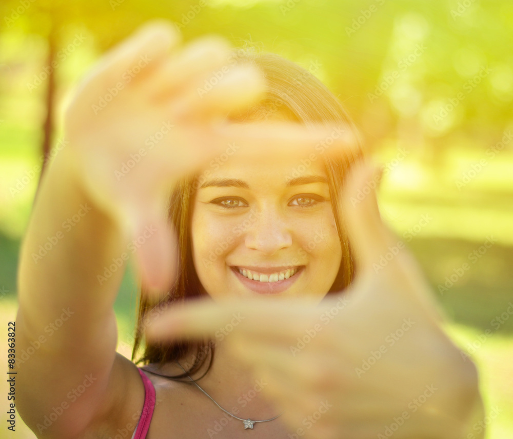 Beautiful girl making frame with hands while outdoors Beautiful girl making frame with hands while outdoors
