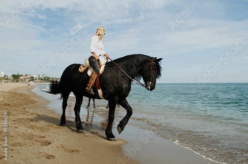 Mujer a caballo por la playa