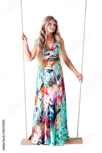 beautiful woman in a long dress on a swing