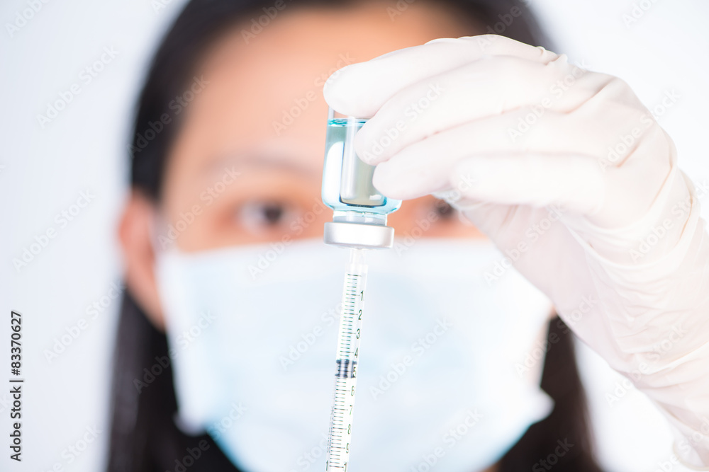 Closed up Nurse fills syringe from injection vial on white Closed up Nurse fills syringe from injection vial on white