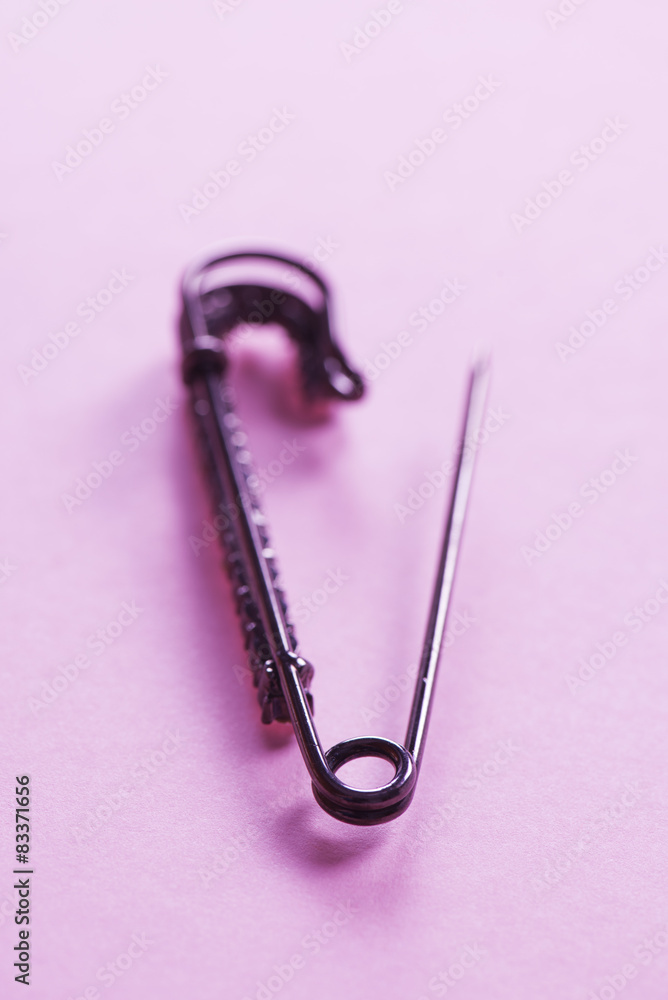 Safety pin on pink background Safety pin on pink background