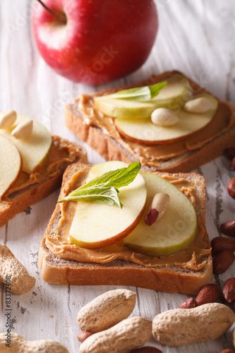 Delicious sandwiches with peanut butter and apple vertical
