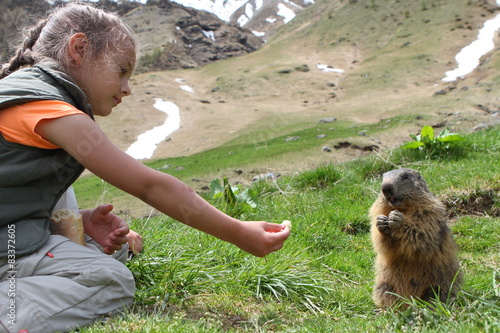 petite fille donnant à manger à une marmotte photo
