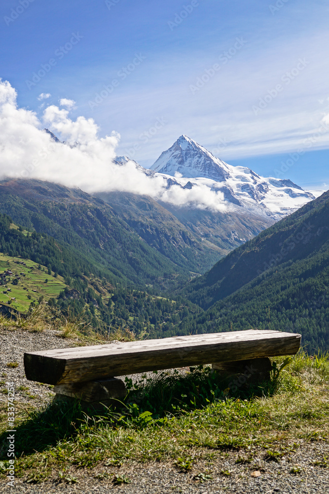 Rustic wooden bench overlooking Swiss Alps in Switzerland.