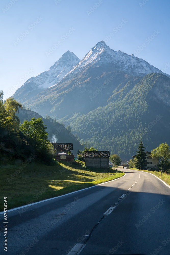 Fototapeta premium Alps Road Lined with Houses in Swiss, Valais, Alps.