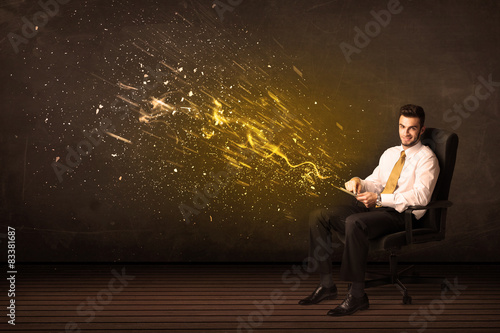 Businessman with tablet and energy explosion on background