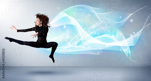 Cute teenager jumping with abstract blue scarf around her © ra2 studio
