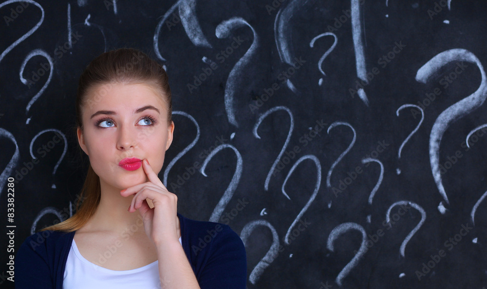 Young girl with question mark on a gray background Young girl with question mark on a gray background