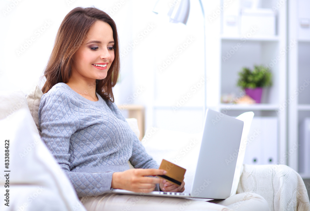 Beautiful smiling woman with laptop and a credit card Beautiful smiling woman with laptop and a credit card