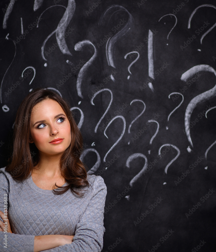 Young girl with question mark on a gray background Young girl with question mark on a gray background