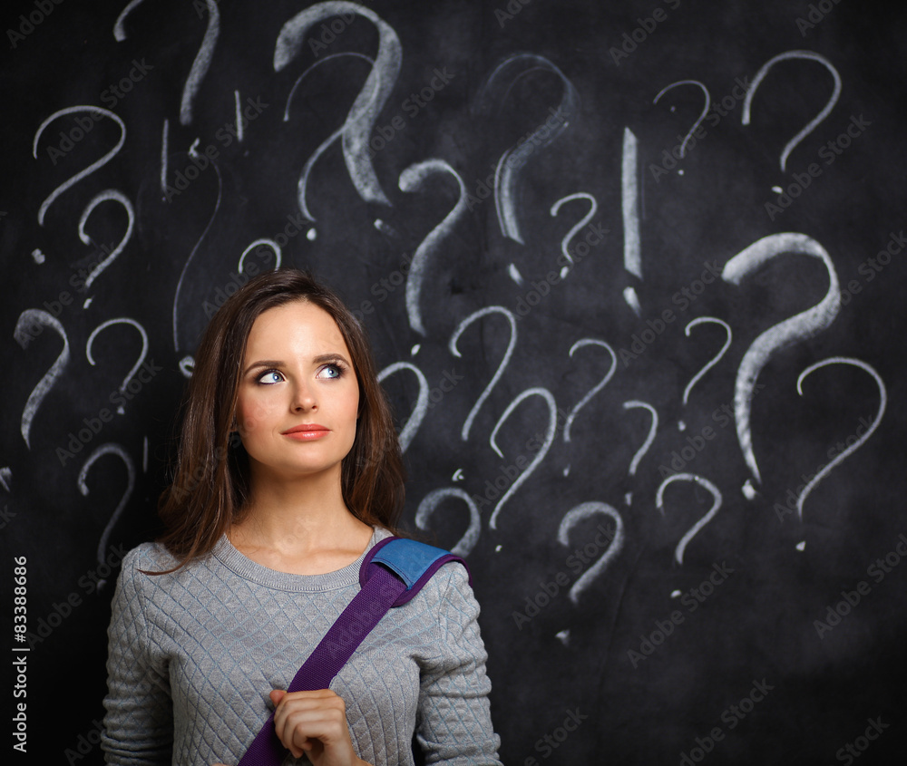 Young girl with question mark on a gray background Young girl with question mark on a gray background