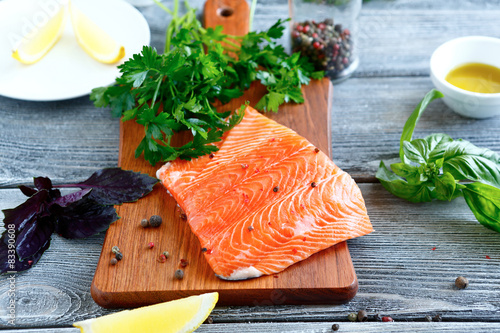 Salmon fillet with parsley, basil and lemon on a cutting board