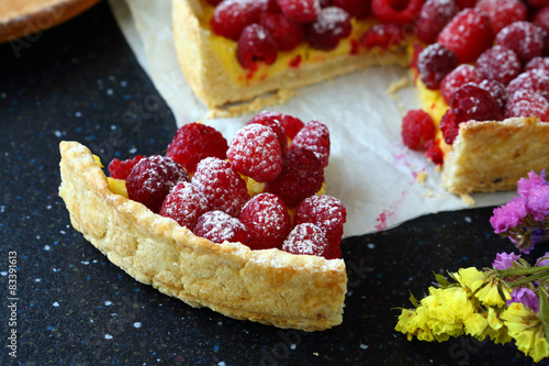 Piece of sweet pie with raspberries on slate