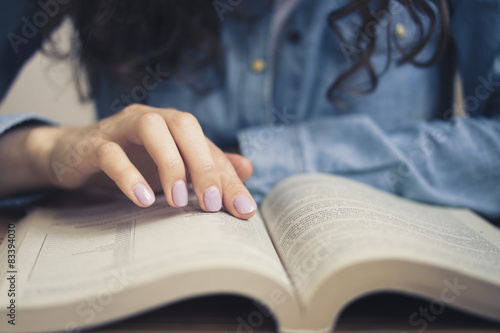 Girl in a denim shirt is reading a book