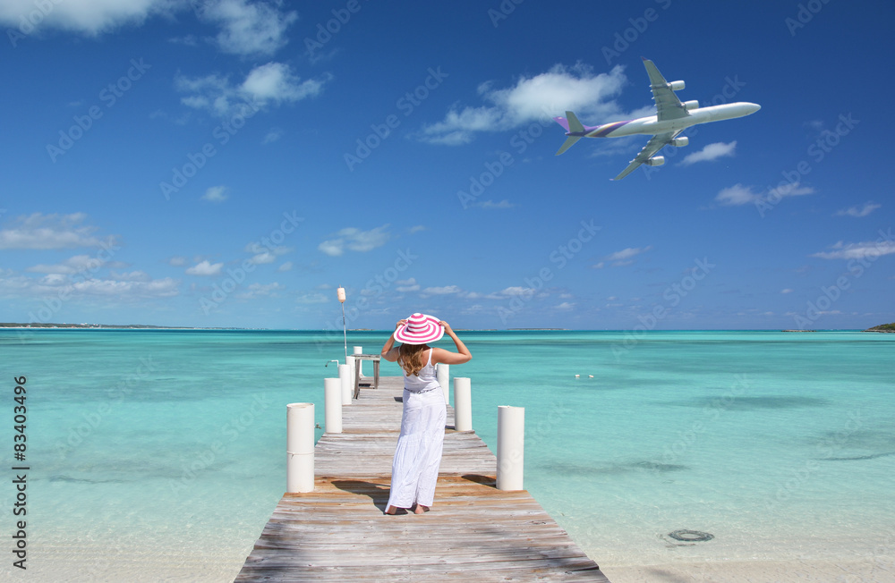 Obraz premium Girl on the wooden jetty looking to the ocean. Exuma, Bahamas