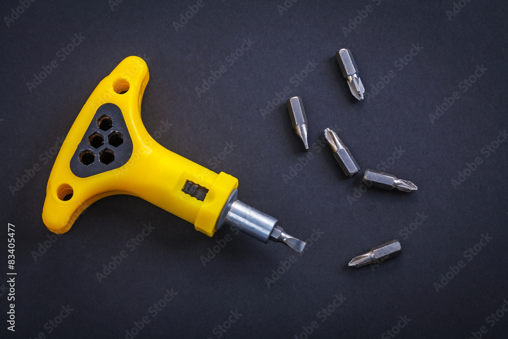 horizontal version yellow screwdriver with little bits on black horizontal version yellow screwdriver with little bits on black