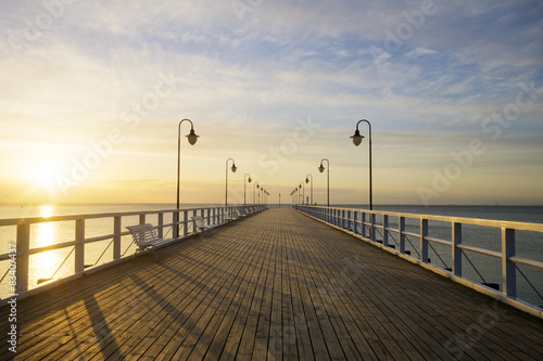Fototapeta Naklejka Na Ścianę i Meble -  The wooden pier on the sea at sunrise