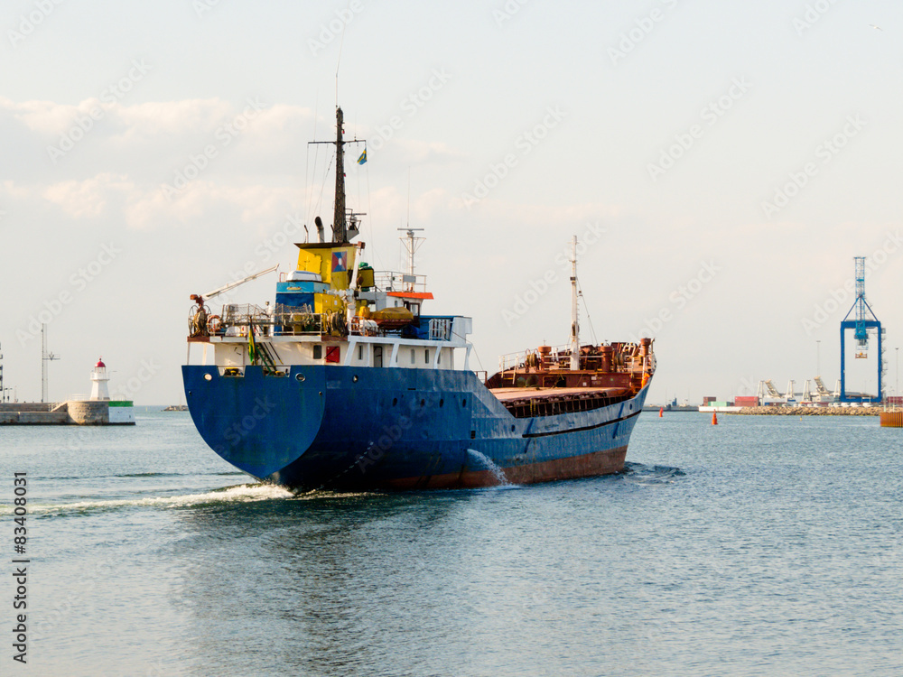 Naklejka premium The cargoship leaves harbor