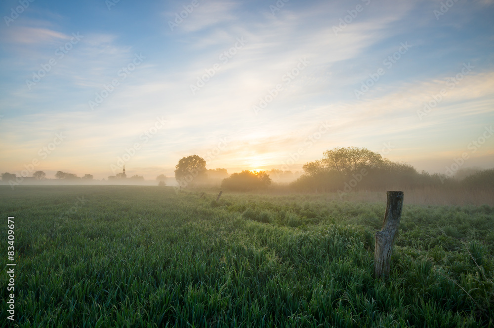 beautiful, misty sunrise on a field near the village