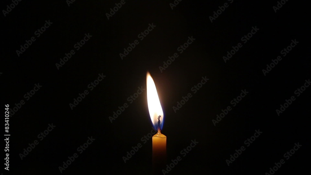 Wax candles burning on a black background Wax candles burning on a black background