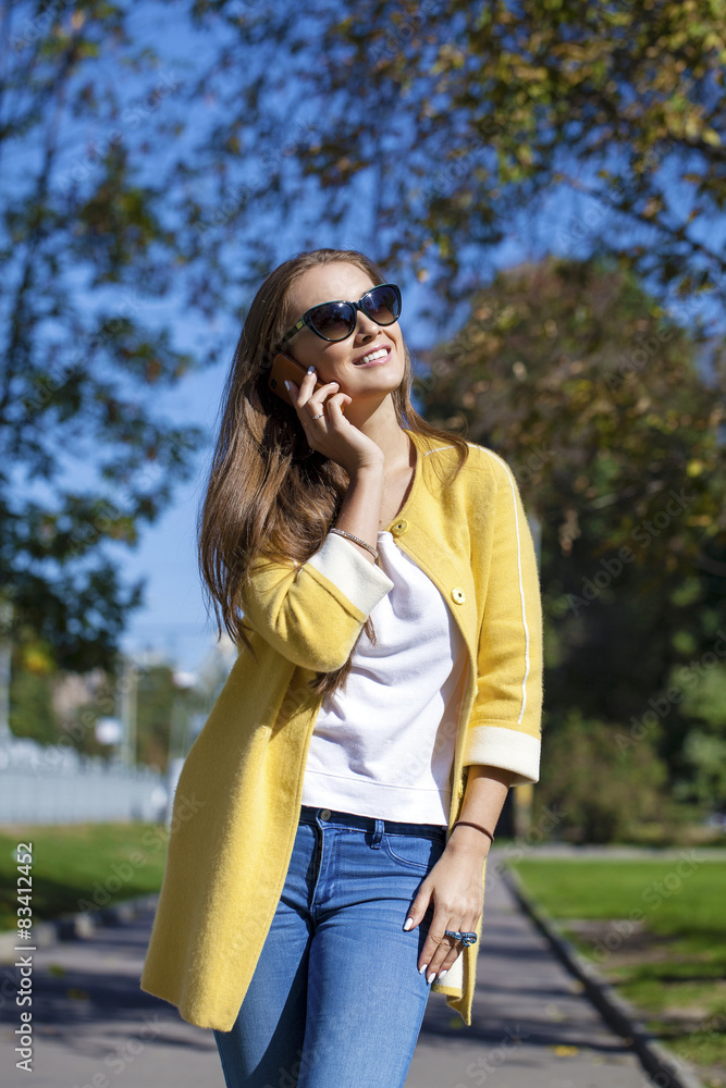 Happy beautiful girl calling by phone