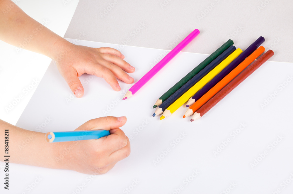 Child drawing in sketchbook with color pencils. Child drawing in sketchbook with color pencils.