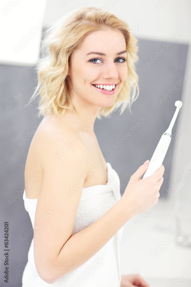 Happy woman brushing teeth
