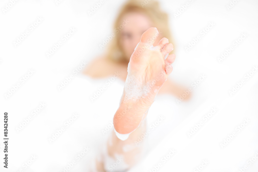 Fototapeta premium Woman showing her foot in a bath