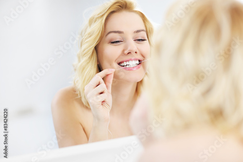 Tablou canvas Woman using dental floss
