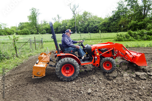 Fényképezés Older Farmer Tilling His Garden With His Compact 4x4 Tractor