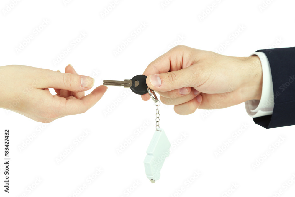 Male hand giving key with trinket to female hand isolated on white Male hand giving key with trinket to female hand isolated on white