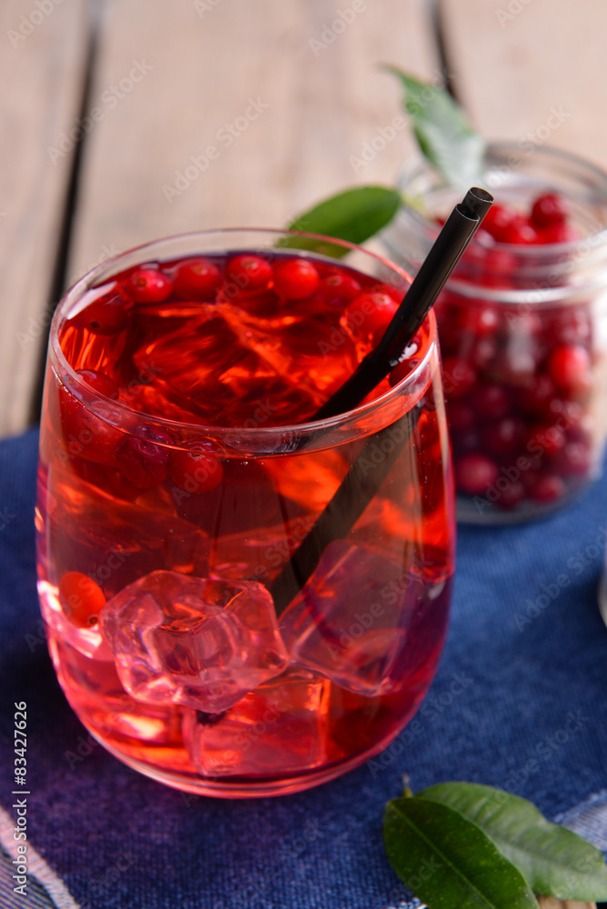 Compote with red currant in glassware on jeans cloth on wooden background Compote with red currant in glassware on jeans cloth on wooden background