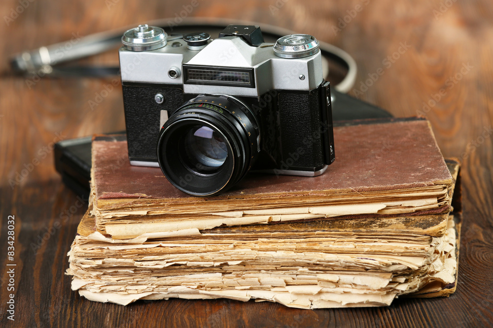 Retro camera with old book on table on green background