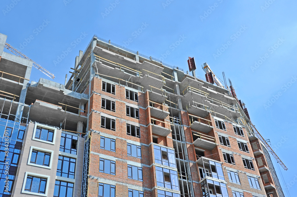Fototapeta premium Crane and building construction site against blue sky