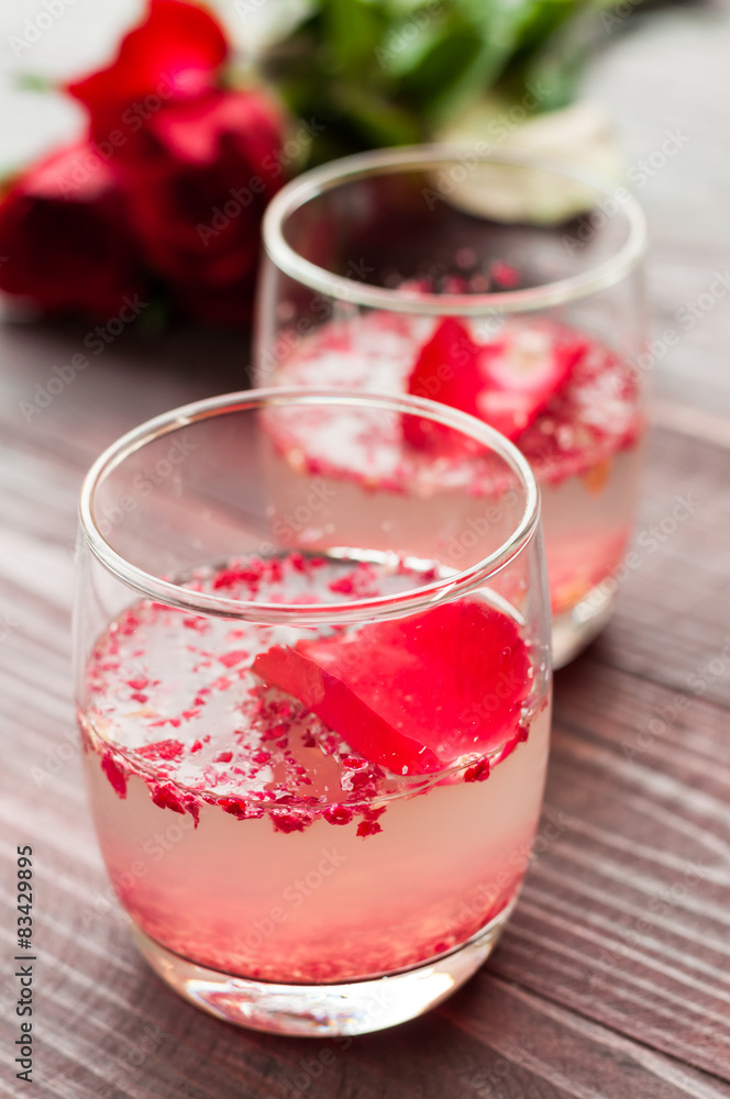 Pink Cocktail with fresh rose petals on wooden table Pink Cocktail with fresh rose petals on wooden table
