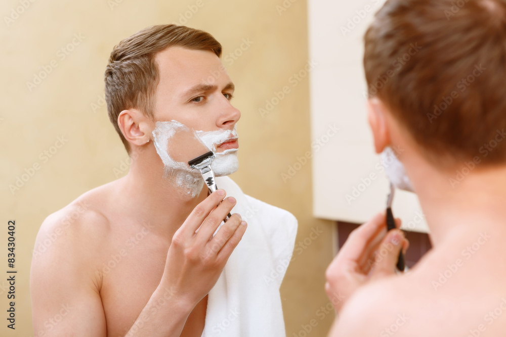 Man shaving in front of mirror 