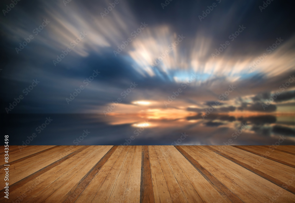 Beautiful sunset long exposure image over ocean with wooden plan