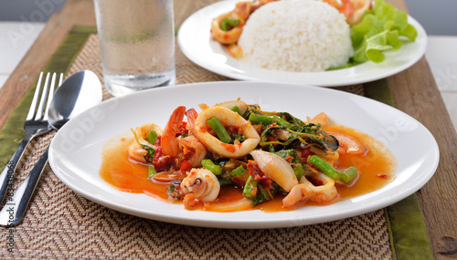 stir fried squid with chilli and basil on white plate