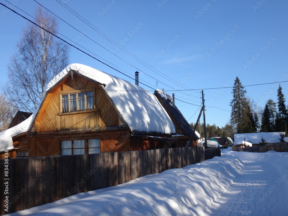 Деревенская улица с деревянными домами зимой