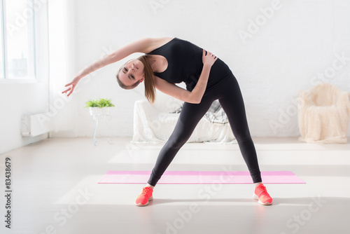 fitness slim girl doing yoga stretching exercise side body