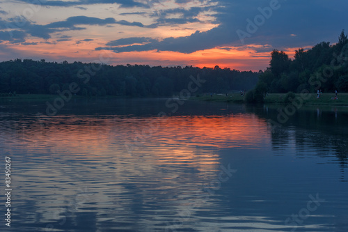 Summer evening landscape after sunset on a pond in the forest