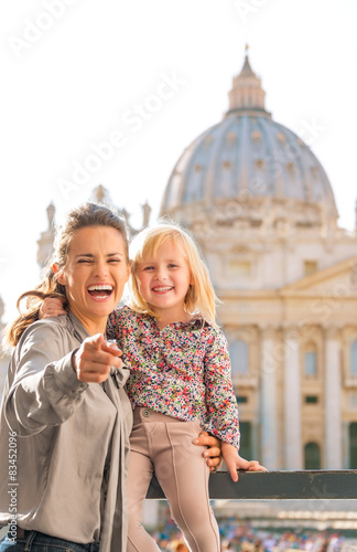 At the Vatican in Rome, laughing mother holds child and points