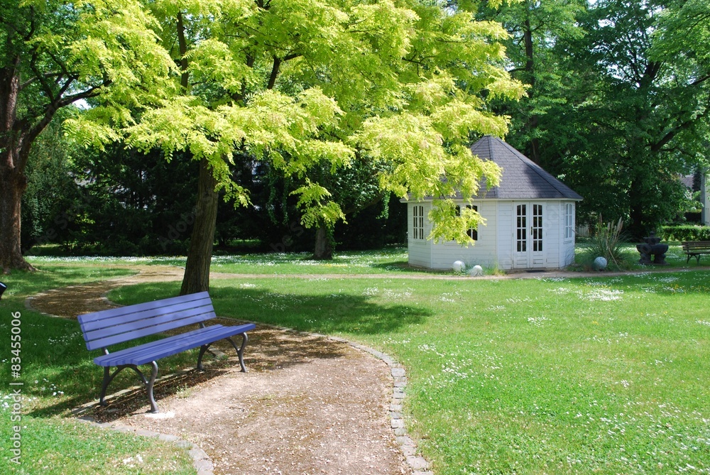 Fototapeta premium Blaue Bank in einem idyllischen Park