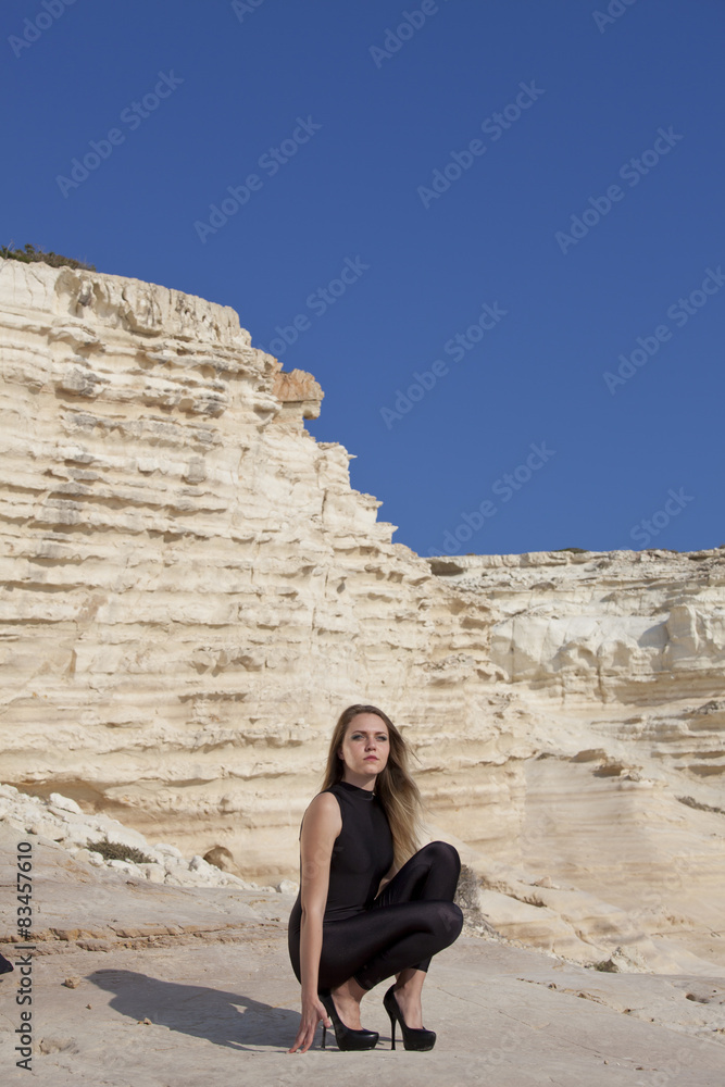Woman in black catsuit on the rocks