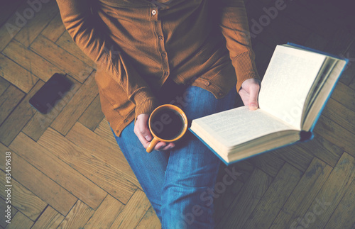 girl reading book and drinking fresh coffee photo