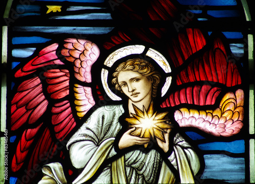 An angel holding the star of Bethlehem in stained glass
