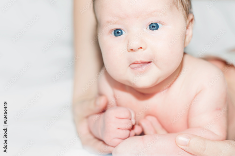 newborn baby girl lying on her stomach on a white bed newborn baby girl lying on her stomach on a white bed