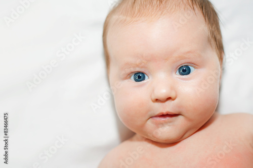 Portrait of newborn girl with blue eyes looking at you